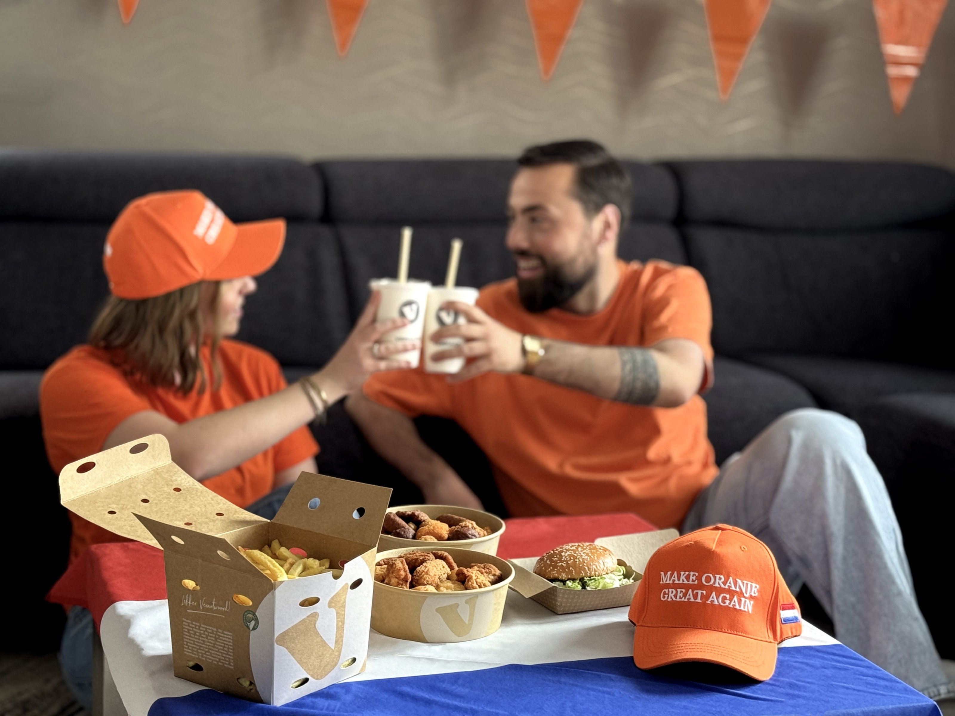 Een goedgevulde Verhage snackbucket en friet op tafel tijdens het kijken van een WK-wedstrijd in Rotterdam.